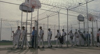 Movie still from “My Cousin Vinny” (1992), directed by Jonathan Lynn – A group of men standing next to each other on top of a basketball court; Wide shot, High angle