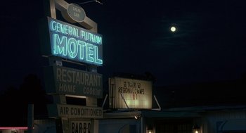 Movie still from “My Cousin Vinny” (1992), directed by Jonathan Lynn – A motel sign lit up at night with a full moon in the background; Wide shot, Low angle
