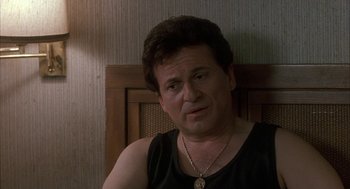 Movie still from “My Cousin Vinny” (1992), directed by Jonathan Lynn – A person sitting in a chair wearing a necklace; Close Up shot, Over the shoulder angle