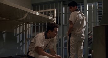 Movie still from “My Cousin Vinny” (1992), directed by Jonathan Lynn – A couple of men sitting next to each other in front of a jail cell; Medium shot, Low angle