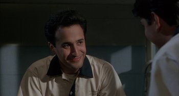 Movie still from “My Cousin Vinny” (1992), directed by Jonathan Lynn – A man in a white shirt and a black tie smiling; Close Up shot, Low angle