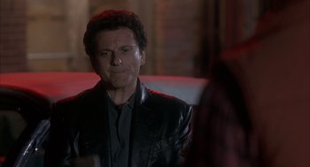 Movie still from “My Cousin Vinny” (1992), directed by Jonathan Lynn – A man wearing a black leather jacket looking at the camera; Close Up shot, Over the shoulder angle