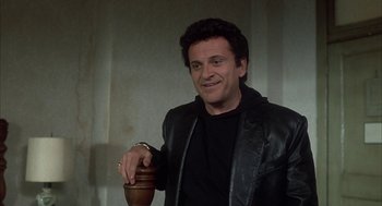 Movie still from “My Cousin Vinny” (1992), directed by Jonathan Lynn – A man in a black jacket is holding a vase; Medium shot, Over the shoulder angle