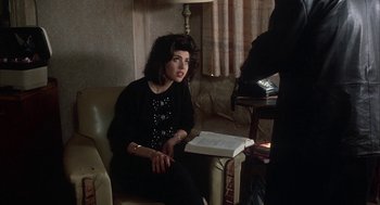 Movie still from “My Cousin Vinny” (1992), directed by Jonathan Lynn – A woman sitting in a chair holding a book; Medium shot, High angle