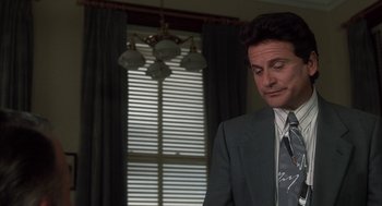 Movie still from “My Cousin Vinny” (1992), directed by Jonathan Lynn – A man in a suit and tie standing in front of a window; Close Up shot, Over the shoulder angle