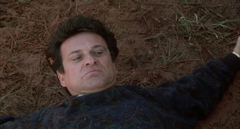 Movie still from “My Cousin Vinny” (1992), directed by Jonathan Lynn – A man laying on the ground in the dirt; Close Up shot, Low angle