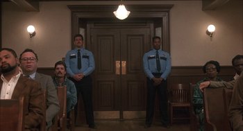 Movie still from “My Cousin Vinny” (1992), directed by Jonathan Lynn – Two security guards standing in front of a door; Wide shot, Low angle