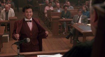 Movie still from “My Cousin Vinny” (1992), directed by Jonathan Lynn – A man standing in front of a microphone in a courtroom; Medium shot, Low angle