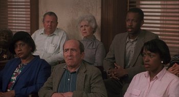 Movie still from “My Cousin Vinny” (1992), directed by Jonathan Lynn – A group of people sitting next to each other in a room; Medium shot, High angle