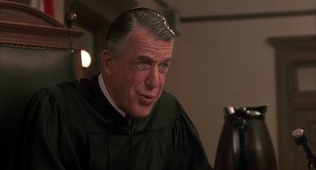 Movie still from “My Cousin Vinny” (1992), directed by Jonathan Lynn – An older man wearing a black robe in a room; Close Up shot, Low angle