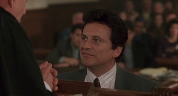 Movie still from “My Cousin Vinny” (1992), directed by Jonathan Lynn – A person wearing a suit and tie; Close Up shot, Over the shoulder angle