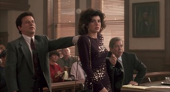 Movie still from “My Cousin Vinny” (1992), directed by Jonathan Lynn – A woman standing in front of a group of people; Medium shot, Over the shoulder angle