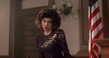 Movie still from “My Cousin Vinny” (1992), directed by Jonathan Lynn – A woman in a black dress is posing for a picture; Medium shot, Over the shoulder angle