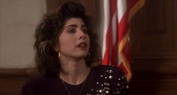Movie still from “My Cousin Vinny” (1992), directed by Jonathan Lynn – A person wearing a black shirt; Close Up shot, Over the shoulder angle
