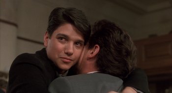 Movie still from “My Cousin Vinny” (1992), directed by Jonathan Lynn – Two men embracing each other in a room; Close Up shot, Over the shoulder angle