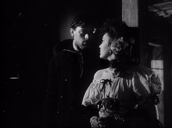 A man and a woman standing next to each other in front of a wall