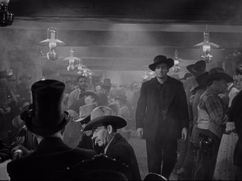 Movie still from “My Darling Clementine” (1946), directed by John Ford – A black and white photo of a group of people in a room; Wide shot, Low angle