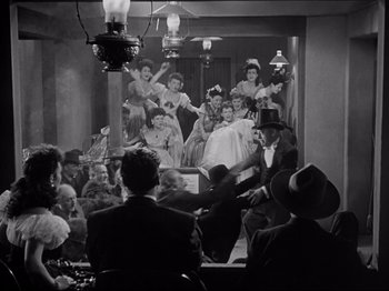 Movie still from “My Darling Clementine” (1946), directed by John Ford – A group of people sitting in front of a screen; Wide shot, High angle