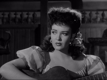 Movie still from “My Darling Clementine” (1946), directed by John Ford – A black and white photo of a woman holding a guitar; Close Up shot, Low angle