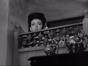 Movie still from “My Darling Clementine” (1946), directed by John Ford – A black - and - white photo of a woman looking over a railing; Medium shot, Low angle
