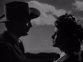 Movie still from “My Darling Clementine” (1946), directed by John Ford – A man and a woman standing next to each other in front of a cloudy sky; Close Up shot, Low angle