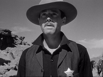 Movie still from “My Darling Clementine” (1946), directed by John Ford – A black and white photo of a man wearing a cowboy hat; Close Up shot, Low angle