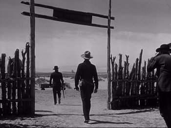 Movie still from “My Darling Clementine” (1946), directed by John Ford – A black and white photo of two men walking on a dirt road; Wide shot, Low angle