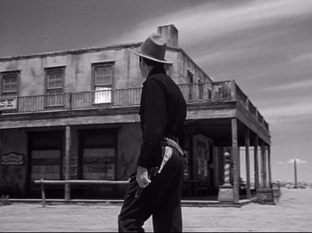 Movie still from “My Darling Clementine” (1946), directed by John Ford – A man walking in front of an old building; Wide shot, Low angle