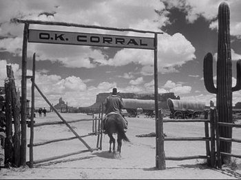 Movie still from “My Darling Clementine” (1946), directed by John Ford – A man riding a horse through a gate; Extreme Wide shot, Low angle