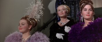 Movie still from “My Fair Lady” (1964), directed by George Cukor – An older woman in a black dress and a purple feather fan; Close Up shot, Low angle