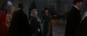 Movie still from “My Fair Lady” (1964), directed by George Cukor – Two women are walking in the dark with a basket; Wide shot, Over the shoulder angle