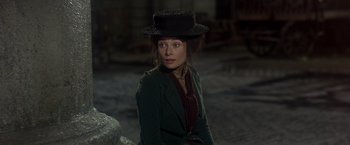 Movie still from “My Fair Lady” (1964), directed by George Cukor – A woman wearing a black hat sitting on the ground; Medium shot, Over the shoulder angle