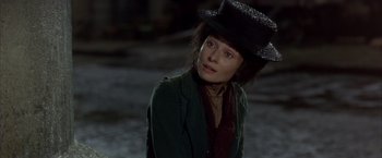 Movie still from “My Fair Lady” (1964), directed by George Cukor – A woman wearing a green jacket and a black hat; Close Up shot, Over the shoulder angle