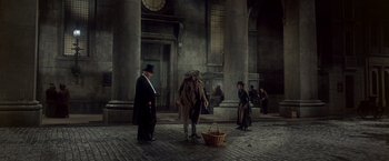 Movie still from “My Fair Lady” (1964), directed by George Cukor – A group of people standing on a brick floor; Wide shot, High angle