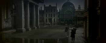 Movie still from “My Fair Lady” (1964), directed by George Cukor – A group of people walking on a street near a building; Extreme Wide shot, High angle