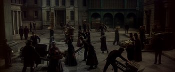 Movie still from “My Fair Lady” (1964), directed by George Cukor – A group of people walking on a street; Extreme Wide shot, High angle