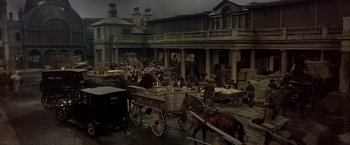 Movie still from “My Fair Lady” (1964), directed by George Cukor – A horse drawn carriage in the middle of an old town; Extreme Wide shot, High angle