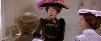 Movie still from “My Fair Lady” (1964), directed by George Cukor – A woman wearing a hat and a brown dress; Close Up shot, Low angle