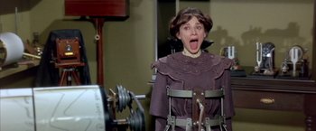 Movie still from “My Fair Lady” (1964), directed by George Cukor – A woman in a purple dress and a black bird; Medium shot, Low angle