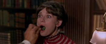 Movie still from “My Fair Lady” (1964), directed by George Cukor – A young woman is eating a pickle in a restaurant; Close Up shot, High angle