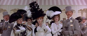 Movie still from “My Fair Lady” (1964), directed by George Cukor – A group of women wearing fancy hats in front of a crowd; Medium shot, Low angle