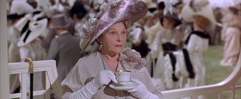 Movie still from “My Fair Lady” (1964), directed by George Cukor – An older woman wearing a hat and holding a tea cup; Close Up shot, Low angle