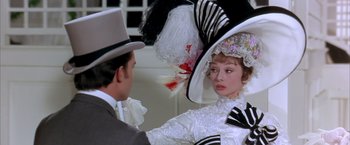 Movie still from “My Fair Lady” (1964), directed by George Cukor – A man and a woman wearing hats and a dress; Close Up shot, Over the shoulder angle
