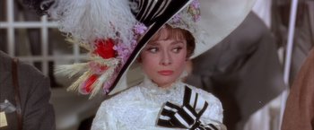 Movie still from “My Fair Lady” (1964), directed by George Cukor – A person wearing a dress and a hat; Close Up shot, Over the shoulder angle