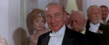 Movie still from “My Fair Lady” (1964), directed by George Cukor – An older man wearing a tuxedo in front of a crowd; Close Up shot, Low angle