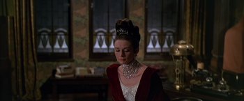 Movie still from “My Fair Lady” (1964), directed by George Cukor – A woman wearing a tiara and a red dress; Close Up shot, Over the shoulder angle