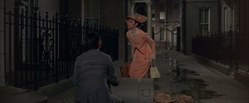 Movie still from “My Fair Lady” (1964), directed by George Cukor – A man and a woman are standing on the sidewalk; Wide shot, High angle