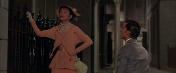 Movie still from “My Fair Lady” (1964), directed by George Cukor – A woman wearing a hat and a pink dress; Medium shot, Over the shoulder angle