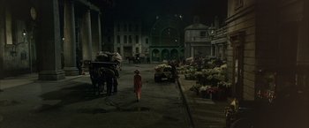 Movie still from “My Fair Lady” (1964), directed by George Cukor – A woman in a pink dress walking down a street; Extreme Wide shot, High angle