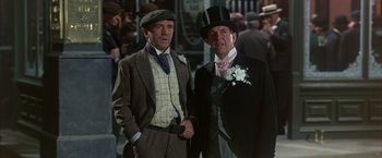 Movie still from “My Fair Lady” (1964), directed by George Cukor – Two men in suits and top hats standing next to each other; Medium shot, Low angle